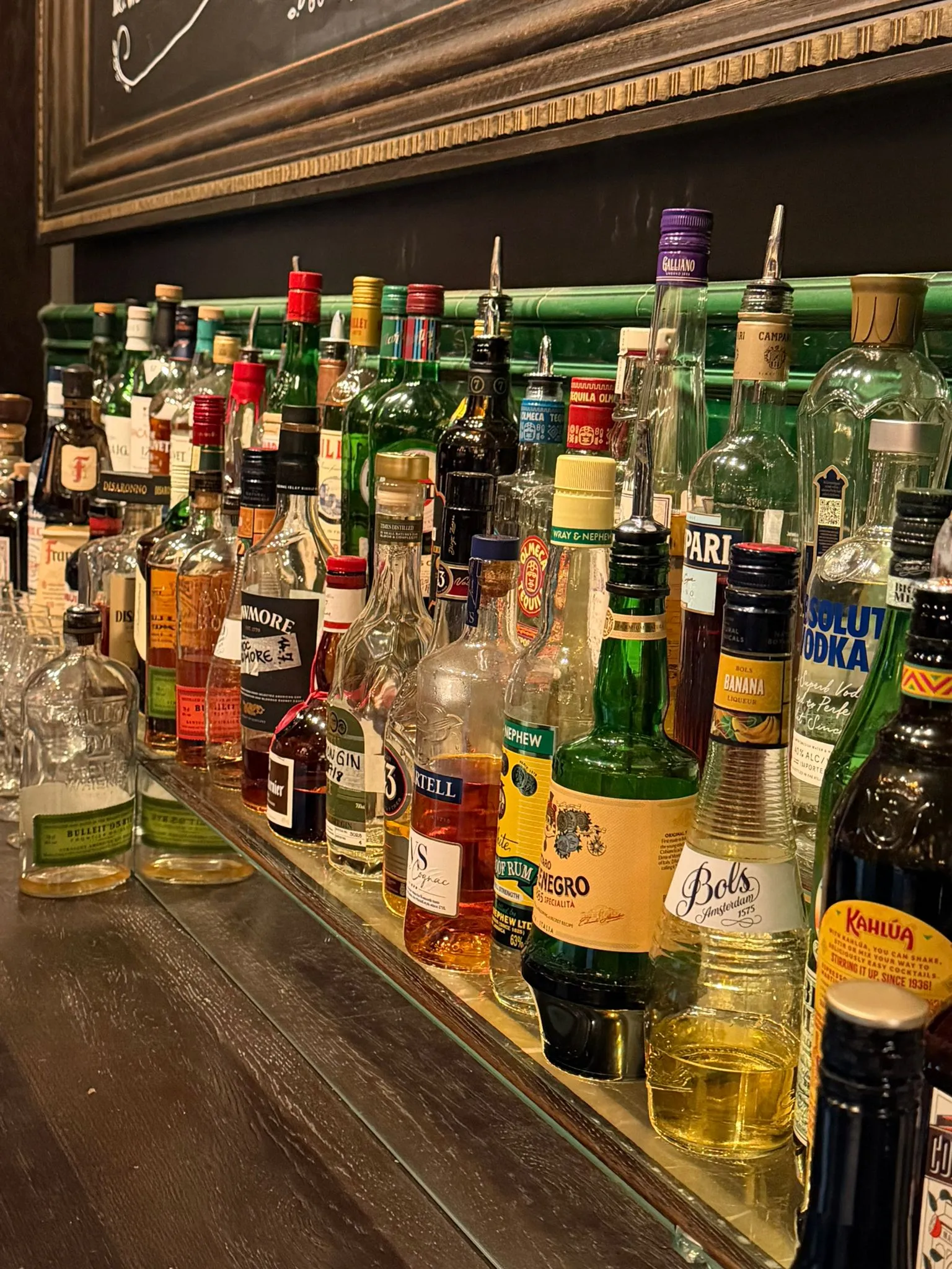 Spritflaskorna bakom baren på Bierhuis, uppradade på spegelhyllan
